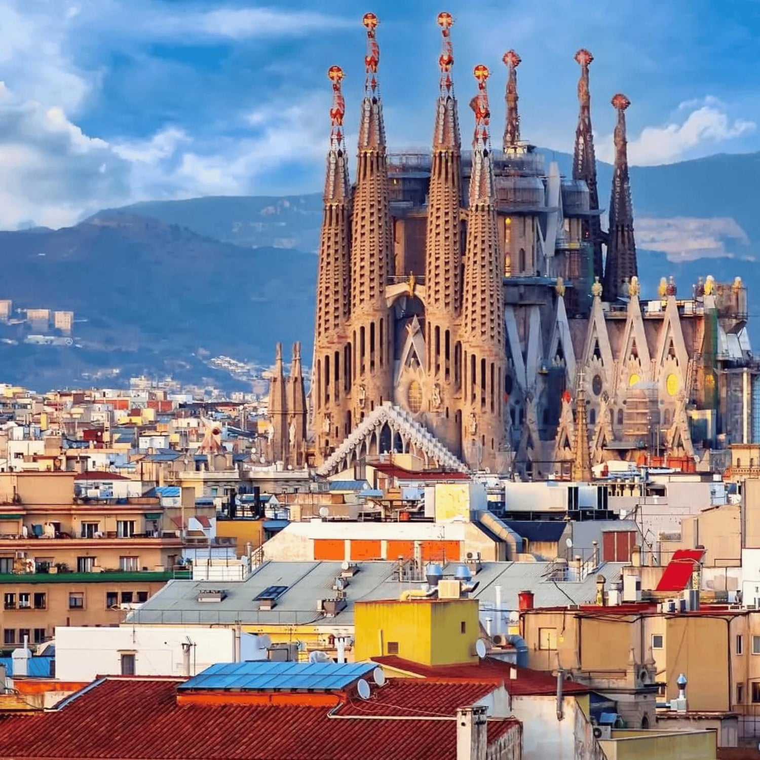 La Sagrada Família in Barcelona skyline with city rooftops and mountain backdrop