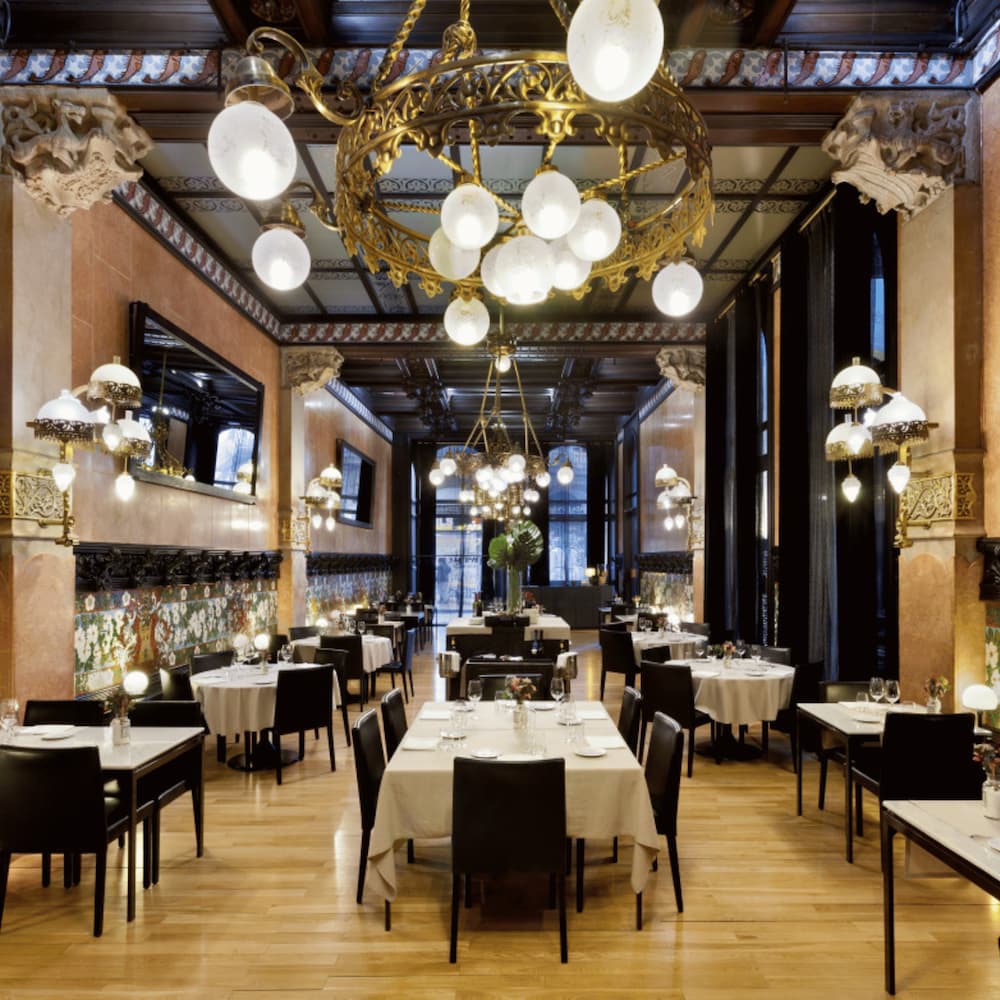 Fonda Espanya Barcelona, Creatively presented tasting plates & mains in an elegant space with intri-cate art & vintage lamps.